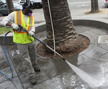 City worker washing down sidewalk