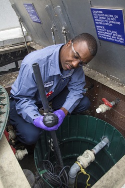 technician adjusting a pipe fitting