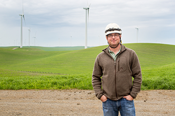 SFPUC employee standing with wind turbines