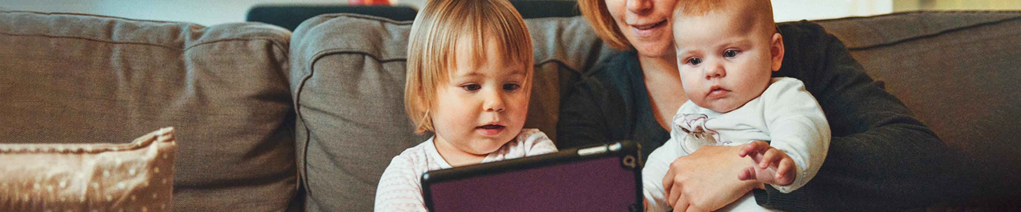 baby and toddler looking at a tablet device