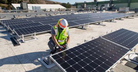 Person working on a rooftop solar panel array