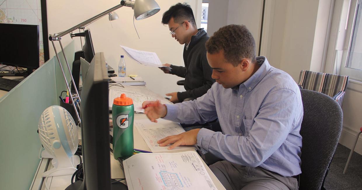 Karl Clayter (front) reviewing engineering design plans with fellow intern Kenneth Mai. 